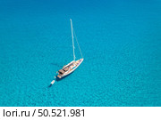 Aerial view of beautiful sailboat in blue sea at sunset in summer. Sardinia, Italy. Top drone view of yacht, ocean with transparent azure water. Travel. Tropical landscape. Yachting. Seascape. Boat. Стоковое фото, агентство Ingram Publishing / Фотобанк Лори