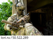 A gun, the personal weapon of a special forces soldier in camouflage, Take refuge in an abandoned building before starting a new patrol operation. Стоковое фото, агентство Ingram Publishing / Фотобанк Лори