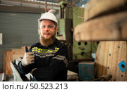 Portrait of mechanical engineers are checking the working condition of an old machine that has been used for some time. In a factory where natural light shines onto the workplace. Стоковое фото, агентство Ingram Publishing / Фотобанк Лори