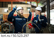 Portrait of mechanical engineers are checking the working condition of an old machine that has been used for some time. In a factory where natural light shines onto the workplace. Стоковое фото, агентство Ingram Publishing / Фотобанк Лори