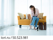 Portrait of young asian woman sitting on sofa in the shop’s VIP lounge with shopping bags. Стоковое фото, агентство Ingram Publishing / Фотобанк Лори
