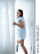 Young asian woman with prosthetics standing by the window in hospital and smiling. Стоковое фото, агентство Ingram Publishing / Фотобанк Лори