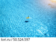 Aerial view of with man and woman on sup board in blue sea at sunset in summer. People on floating canoe in transparent water. Kayak. Sardinia island, Italy. Tropical seascape. Active travel. Top view. Стоковое фото, агентство Ingram Publishing / Фотобанк Лори