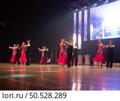 Gomel, Belarus - Sept 15, 2023: Passionate dancers. Young artistic men and women in beautiful stage costumes dancing ballroom dance at stage under spotlights. Редакционное фото, фотограф Дмитрий Нечаев / Фотобанк Лори