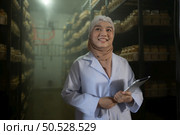Portrait of young asian muslim female scientist doing research at a mushroom factory, examining mushroom leavening agent in a sterile and temperature-controlled room. Стоковое фото, агентство Ingram Publishing / Фотобанк Лори