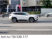 Hyundai Tucson Fourth generation car rides through the city on high speed. Side view of fast moving white suv car on Moscow streets. Редакционное фото, фотограф Константин Григорьев / Фотобанк Лори