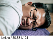 Funny overweight man in glasses closed his eyes and lying exhausted down on the floor after workout, copy space. Стоковое фото, агентство Ingram Publishing / Фотобанк Лори