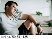 Funny overweight man sitting exhausted down on the floor after workout with dumbbell, copy space. Стоковое фото, агентство Ingram Publishing / Фотобанк Лори