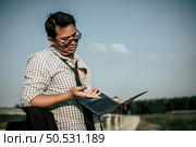Young Asian Businessman with laptop wearing shirt and tie with shorts and eyeglasses with problems and stress or disappointment of work at outside corporate office, copy space. Стоковое фото, агентство Ingram Publishing / Фотобанк Лори