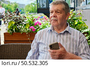 Fraud and deception. A shocked, worried elderly man in the process of talking to a scammer. Стоковое фото, фотограф Терехова Марина / Фотобанк Лори