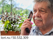 Разговор пенсионера с мошенниками. Fraud and deception. A shocked, worried elderly man in the process of talking to a scammer. Стоковое фото, фотограф Терехова Марина / Фотобанк Лори