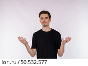 Portrait of puzzled clueless young man arms out asking why what’s the problem who cares so what, I don’t know on isolated background. Стоковое фото, агентство Ingram Publishing / Фотобанк Лори