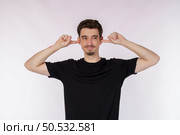 Portrait of attractive man close ears from noisy neighbours, looking up and shouting annoyed, hearing loud music on isolated background. . Стоковое фото, агентство Ingram Publishing / Фотобанк Лори