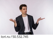 Portrait of puzzled clueless young businessman arms out asking why what’s the problem who cares so what, I don’t know on isolated background. Стоковое фото, агентство Ingram Publishing / Фотобанк Лори