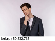 Portrait of young businessman thinking touching chin isolated over white background. Thinking worried about a question, concerned and nervous with hand on chin. Стоковое фото, агентство Ingram Publishing / Фотобанк Лори