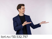 Portrait of happy smiling young businessman presenting and showing your text or product isolated on white background. Empty copyspace area for slogan or advertising text message. Стоковое фото, агентство Ingram Publishing / Фотобанк Лори