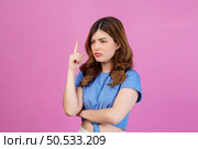 Portrait of young woman wearing casual t-shirt thinking and imagination isolated over pink background. Expression, people and lifestyle concept. Стоковое фото, агентство Ingram Publishing / Фотобанк Лори