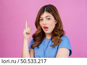 Portrait of excited young woman wearing casual t-shirt thinking and imagination isolated over pink background. Expression, people and lifestyle concept. Стоковое фото, агентство Ingram Publishing / Фотобанк Лори