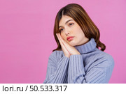Portrait of beautiful young woman thinking about new idea and looking at something isolated over pink background. People lifestyle concept. Стоковое фото, агентство Ingram Publishing / Фотобанк Лори
