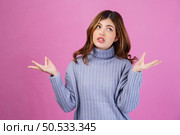 Portrait of confused young woman shrugging shoulders in bewilderment, doubting and feeling uncertain, don’t know answer. isolated over pink background. Emotion concept. Стоковое фото, агентство Ingram Publishing / Фотобанк Лори