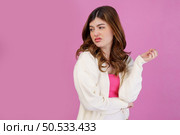 Portrait of disgusted young woman looking something isolated over pink background. People lifestyle and expression concept. Стоковое фото, агентство Ingram Publishing / Фотобанк Лори