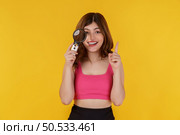 Portrait of cheerful detective pretty woman looking at camera through magnifying glass isolated over yellow background. Investigation, discovery and vision concept. Стоковое фото, агентство Ingram Publishing / Фотобанк Лори