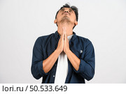 Portrait of Disappointed young asian man in blue shirt annoyed angry in furious gesture isolated on white background. Expression and lifestyle concept. Стоковое фото, агентство Ingram Publishing / Фотобанк Лори