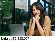 Pretty asian woman sitting and enjoy to listening musice from wireless headphone and singing together with smartphone at cafe, relaxing and lifestyle concept. Стоковое фото, агентство Ingram Publishing / Фотобанк Лори