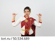 Portrait young pretty woman dress up in beautiful  local culture in northern region with upset posture, grimace and thumb down on white background, copy space. Стоковое фото, агентство Ingram Publishing / Фотобанк Лори
