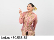 Portrait Young beautiful woman dress up in local culture in southern region with charming gesture smile and point finger  out on white background, copy space. Стоковое фото, агентство Ingram Publishing / Фотобанк Лори
