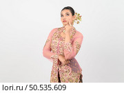 Young beautiful woman dress up in local culture in southern region with thoughtful posture on white background, copy space. Стоковое фото, агентство Ingram Publishing / Фотобанк Лори