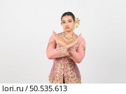 Young beautiful woman dress up in local culture in southern region with feel bad and denied on posing cross her hands with feel upset and grimace on white background, copy space. Стоковое фото, агентство Ingram Publishing / Фотобанк Лори