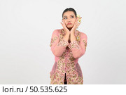 Young beautiful woman dress up in local culture in southern region with thoughtful posture on white background, copy space. Стоковое фото, агентство Ingram Publishing / Фотобанк Лори