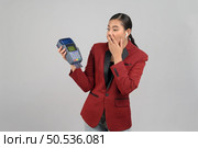 Portrait Asian young woman in officer uniform feel excited  to showing credit card and payment machine, copy space for insert advertising your product, isolated on white background. Стоковое фото, агентство Ingram Publishing / Фотобанк Лори