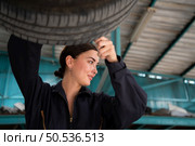 A mechanic for automobiles examining the condition of tires that have been in use for some time. Стоковое фото, агентство Ingram Publishing / Фотобанк Лори