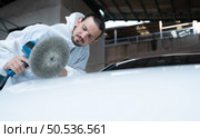 Auto mechanic use an electric polisher to polish the dried car paint. After passing the paint from the car painting room. Стоковое фото, агентство Ingram Publishing / Фотобанк Лори