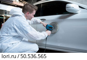 Auto mechanic use an electric polisher to polish the dried car paint. After passing the paint from the car painting room. Стоковое фото, агентство Ingram Publishing / Фотобанк Лори