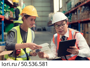 Before exporting to other nations, The product owner meets with the foreman and warehouse personnel to verify their own items held at this warehouse. Стоковое фото, агентство Ingram Publishing / Фотобанк Лори