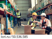Before exporting to other nations, The product owner meets with the foreman and warehouse personnel to verify their own items held at this warehouse. Стоковое фото, агентство Ingram Publishing / Фотобанк Лори