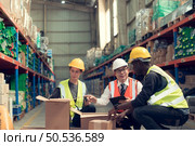 Before exporting to other nations, The product owner meets with the foreman and warehouse personnel to verify their own items held at this warehouse. Стоковое фото, агентство Ingram Publishing / Фотобанк Лори