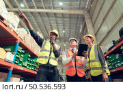 Before exporting to other nations, The product owner meets with the foreman and warehouse personnel to verify their own items held at this warehouse. Стоковое фото, агентство Ingram Publishing / Фотобанк Лори