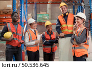 Managers, foremen and warehouse workers Consult together about getting the goods out of the warehouse to finish sending the small merchants tonight. Стоковое фото, агентство Ingram Publishing / Фотобанк Лори