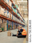 A warehouse employee was injured in an accident. because the product package fell from the shelves and crushed the employee’s leg severely. Стоковое фото, агентство Ingram Publishing / Фотобанк Лори