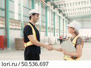Meeting between designer and warehouse manager to organize the arrangement of product shelves in a huge, empty warehouse. Стоковое фото, агентство Ingram Publishing / Фотобанк Лори