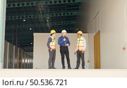 A warehouse manager and two employees are resting after dealing with how to organize the shelves in a large warehouse. Стоковое фото, агентство Ingram Publishing / Фотобанк Лори
