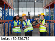 Group of employees in an auto parts warehouse, Examine auto parts that are ready to be shipped to the automobile assembly factory. Стоковое фото, агентство Ingram Publishing / Фотобанк Лори