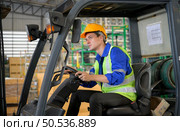 Worker in auto parts warehouse use a forklift to work to bring the box of auto parts into the storage shelf of the warehouse waiting for delivery to the car assembly line. Стоковое фото, агентство Ingram Publishing / Фотобанк Лори