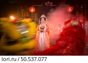 Chinese woman with yellow and red lions It is considered to enhance the prosperity for oneself on the occasion of the Chinese New Year festival every year and in Chinese, it means prosperous, fortunate, happy, prosperous. Стоковое фото, агентство Ingram Publishing / Фотобанк Лори