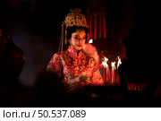 Chinese woman make wishes, pray, and light candles. On the occasion of the annual Chinese New Year festival, in a revered shrine or temple, And in Chinese where candles mean good luck and happiness. Стоковое фото, агентство Ingram Publishing / Фотобанк Лори