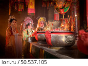 Male and female Chinese opera actors Light a candle to pray homage to the gods to enhance the prosperity for yourself on the occasion of the Chinese New Year festival. Стоковое фото, агентство Ingram Publishing / Фотобанк Лори